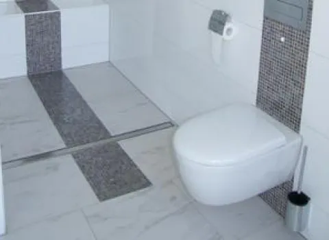 Stilvolle Kombination von Mosaik und Wandtoilette von Brüning.