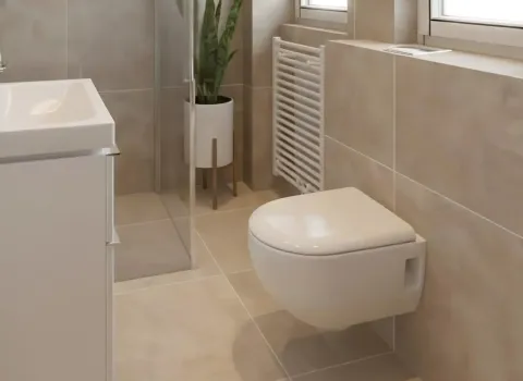 Ein helles, modernes Badezimmer mit wandhängender Toilette und bodengleicher Dusche in beige-grauen Naturtönen. Große Fenster lassen viel Tageslicht in den Raum, was die freundliche Atmosphäre unterstreicht. Ein weißer Heizkörper unter dem Fenster dient gleichzeitig als Handtuchwärmer. Im Duschbereich steht eine grüne Pflanze im Design-Topf als stilvoller Akzent.