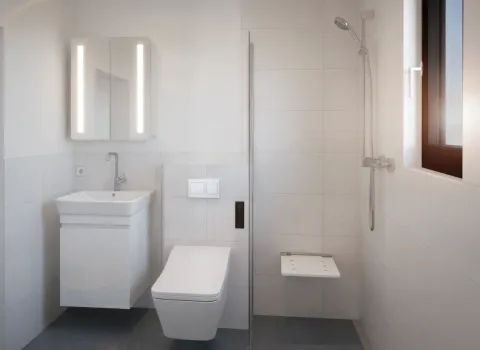 Ein minimalistisches Badezimmer mit hellen Wandfliesen, wandmontiertem Waschplatz, WC und offener Dusche. Der klappbare Sitz in der Dusche erhöht den Komfort. Tageslicht fällt durch ein Fenster neben der Dusche ein.