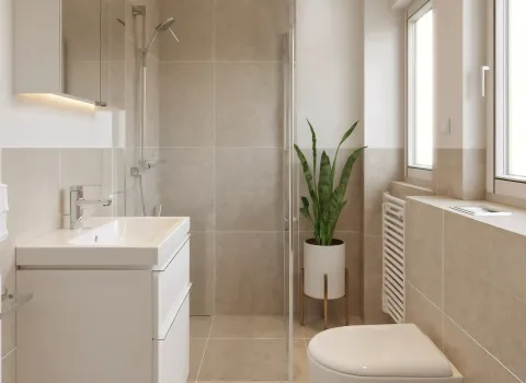 Ein helles, minimalistisch eingerichtetes Badezimmer mit klaren Linien und durchdachtem Layout. Der Waschtisch mit Unterbauschubladen ist platzsparend an der Wand montiert, daneben befindet sich eine bodengleiche Dusche mit Glaswand. Die wandhängende Toilette fügt sich unauffällig ins Design ein. Natürliche Farben, viel Tageslicht und eine dekorative Pflanze sorgen für ein modernes Wohngefühl.
