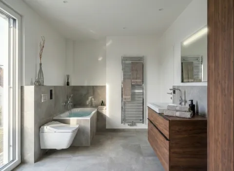 Helles Bad mit großer Fensterfront, freihängender Toilette, Badewanne mit Handbrause und edlem Waschtisch in Holzoptik.