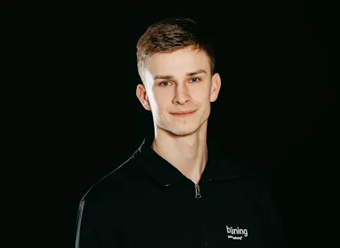 Der Auszubildende Tomasz Wejer vor schwarzen Hintergrund.