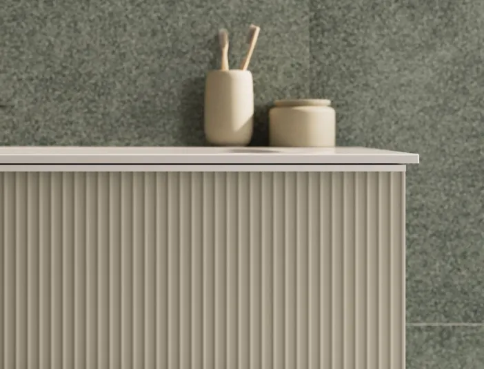 Ein Waschtischunterschrank der Serie burgbad Fiumo 2.0 mit vertikal geriffelter Front in einem warmen Beigeton.