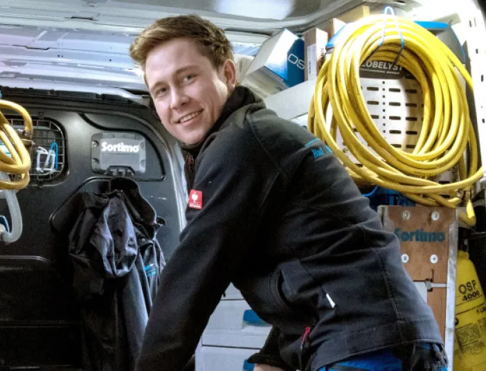 Kundendiensttechniker (SHK) vor Service-Fahrzeug.